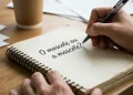 Pessoa escrevendo em um caderno a dúvida sobre o mascote ou a mascote.