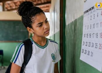 Estudante de escola pública observa calendário na parede após mudanças administrativas do MEC no programa Pé-de-Meia