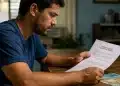 Homem analisando um termo de rescisão com notas de dinheiro sobre a mesa, representando a multa de 40% em caso de demissão sem justa causa.