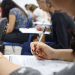 Candidatos realizando prova de concurso público em sala de aula.