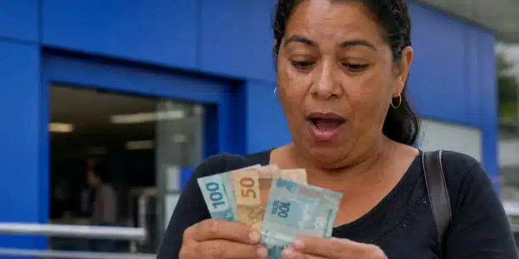 Mulher conferindo dinheiro em agência bancária, representando a confirmação do pagamento de quase R$ 4 mil liberado para CPF com final de 0 a 9.