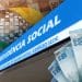 Fachada da Previdência Social e cédulas de 100 reais, representando a folha de pagamento do INSS de junho de 2026.