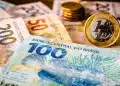 Notas de dinheiro em reais representando a liberação de pagamento do programa Pé-de-Meia em 1º de julho, com foco em benefício educacional.