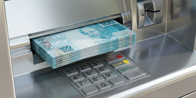 Notas de cem reais saindo da gaveta de um caixa eletrônico