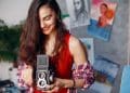 Mulher usa câmera analógica antiga, exemplo de profissões fora de moda que ainda remuneram bem
