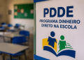 Cartaz do Programa Dinheiro Direto na Escola fixado em sala de aula que aguarda recursos do PDDE 2026