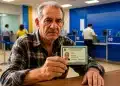 Idoso mostrando carteira de identidade em agência bancária, destacando a importância da prova de vida para aposentados em junho.
