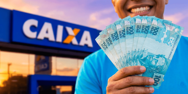 Trabalhador sorri ao segurar cédulas de cem reais em leque diante da fachada de uma agência da Caixa Econômica Federal