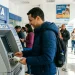 Homem utilizando caixa eletrônico da CAIXA para consultar informações sobre saque calamidade.