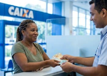 Trabalhadora recebe o Saque Calamidade do FGTS de até R$ 6.220 em uma agência da Caixa.