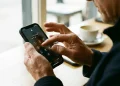 Pessoa digitando a senha de bloqueio no iPhone para aumentar a proteção de dados e a privacidade.