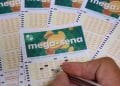 Mão preenchendo volante da Mega-Sena, que paga R$ 42 milhões no sorteio de sábado