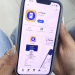 Pessoa segurando celular aberto na página do aplicativo e-Título.