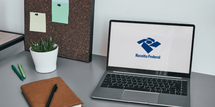 Logo da Receita Federal exibido em notebook sobre mesa de trabalho moderna.