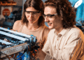 Jovens desenvolvendo projeto de robótica em laboratório moderno.