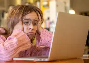 Estudante pesquisando informações sobre o Prouni 2026.2 em notebook após resultado da seleção de bolsas.