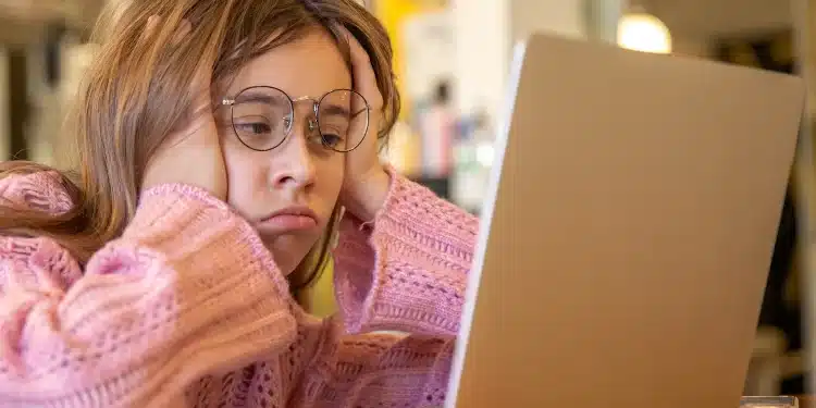 Estudante pesquisando informações sobre o Prouni 2026.2 em notebook após resultado da seleção de bolsas.