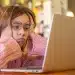 Estudante pesquisando informações sobre o Prouni 2026.2 em notebook após resultado da seleção de bolsas.