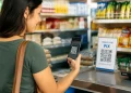 Mulher realizando pagamento via Pix por QR Code em estabelecimento comercial.