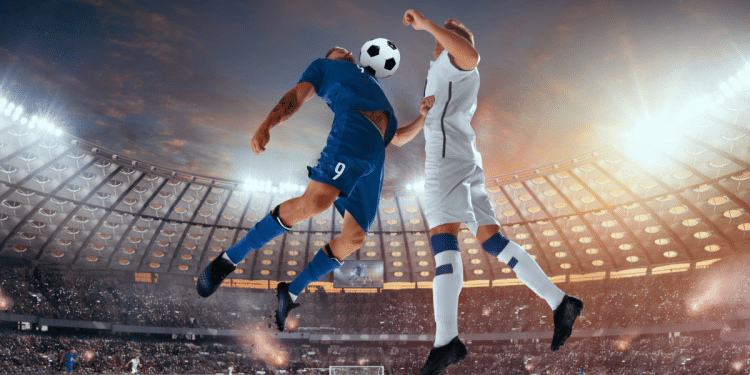 Jogadores duelam de cabeça em partida decisiva de futebol em estádio lotado.