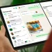 Pessoa segura um iPad com o WhatsApp aberto na tela de conversas e recursos de mensagens.