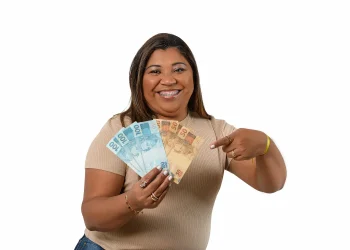 Mulher segurando notas de dinheiro representa possível aumento na aposentadoria das mães com adicional de até 15%.