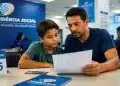 Pai e filho lendo documento durante atendimento no INSS, representando a conferência dos direitos do MEI além da aposentadoria e dos benefícios previdenciários destinados à família.