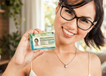 Mulher sorrindo e mostrando a nova Carteira de Identidade Nacional após a emissão da CIN em Manaus
