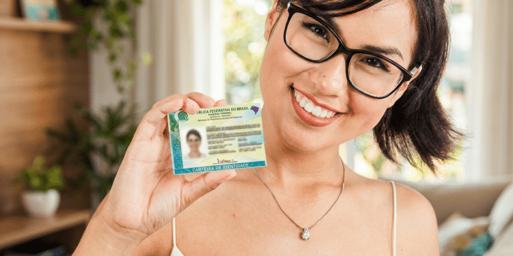 Mulher sorrindo e mostrando a nova Carteira de Identidade Nacional após a emissão da CIN em Manaus