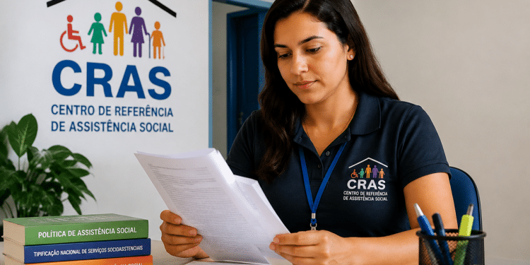 Mulher de cabelo castanho lendo papéis no CRAS com livros e crachá azul sobre a mesa, simbolizando o funcionamento dos concursos com vagas para o CRAS.