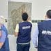 Servidores com colete do IBGE analisam mapa de município fixado na parede durante trabalho de campo