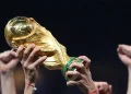 Troféu da Copa do Mundo levantado por torcedores durante a celebração de uma conquista no futebol internacional, simbolizando a dúvida entre semifinal, semi final e semi-final.