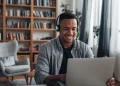 Estudante acompanha curso a distância pelo notebook usando fones de ouvido.