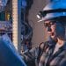 Estudante com capacete e óculos de proteção analisando projeto elétrico durante formação em cursos técnicos gratuitos na Bahia