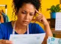 Microempreendedora analisa documentos financeiros em seu ateliê, representando a dúvida sobre se o MEI tem direito ao 13º salário.