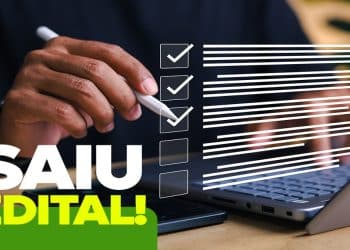 Pessoa marca itens de uma lista em frente ao notebook, representando a publicação do edital do concurso de Porto Alegre para Agente de Fiscalização