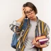 Estudante com livros e mochila demonstra dúvida sobre a escolha do curso.