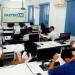 Sala de aula de informática com alunos em computadores durante curso EAD da Faetec, destacando inscrições abertas para vagas gratuitas.