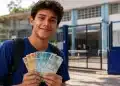 Estudante do ensino médio segura cédulas de real em frente à escola, representando as melhores formas de uso dos R$ 3 mil acumulados pelo Pé-de-Meia