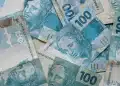 Notas de 100 reais simbolizando pagamentos do INSS em julho de 2026, com destaque para o teto de benefícios de R$ 8.475,55 e consulta via Meu INSS.