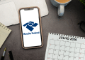 Smartphone exibe logo da Receita Federal ao lado de calendário de julho de 2026 e itens de escritório.