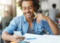 Estudante consulta simulados e exercícios do Enem pelo celular enquanto estuda.