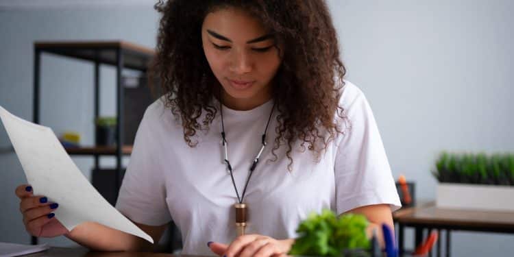 Jovem revisando anotação em folha durante estudo com flashcards, aplicando técnicas de memorização para o Enem 2026