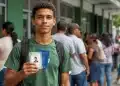 Jovem segura documentos pessoais durante mutirão da Carteira de Identidade Nacional com fila de atendimento em órgão público