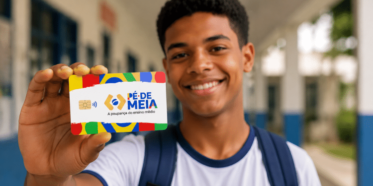 Estudante segurando cartão do programa Pé-de-Meia em escola pública.