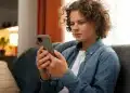 Jovem utilizando celular para acessar plataforma de apoio emocional online.