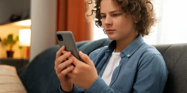 Jovem utilizando celular para acessar plataforma de apoio emocional online.