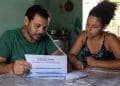 Imagem ilustrativa de um casal analisando um formulário do Cadastro Único em casa, tema da atualização cadastral do BPC.