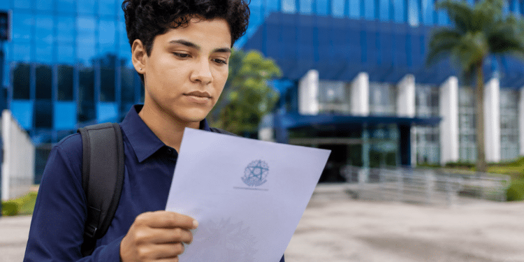 Pessoa segurando documento de nomeação após aprovação em concurso público.