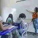 Professora em sala de aula com alunos representando o direito à licença remunerada para qualificação de docentes da rede pública.